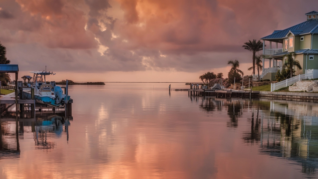 Waterfront homes at Islands of Rockport with ocean view against a pink dawn sky