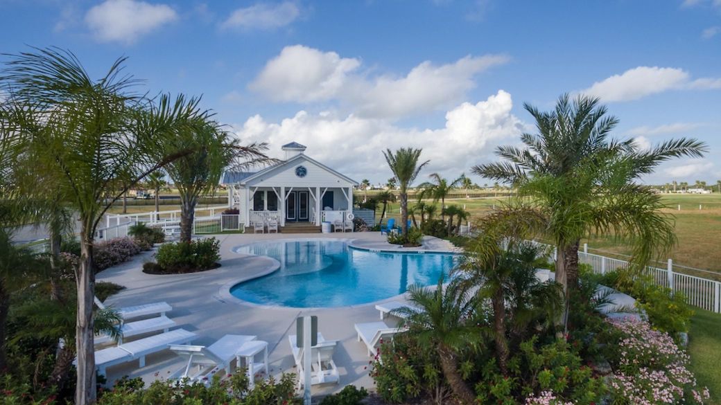 Amenity center with outdoor pool and palm trees at Islands of Rockport